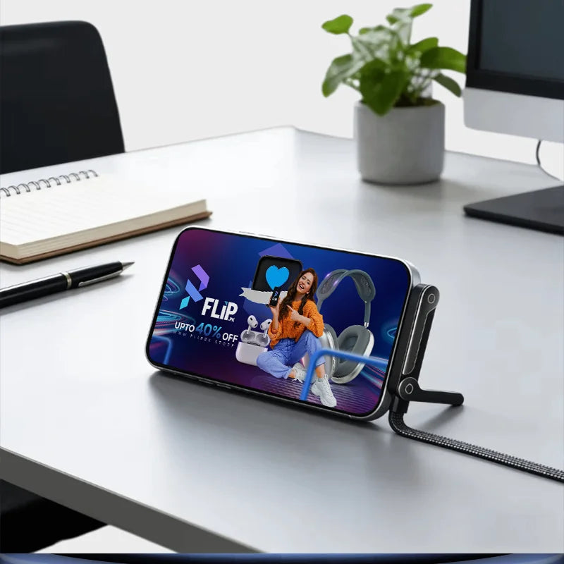 Smartphone with a Flipkart advertisement on a desk with a plant and notebook in the background