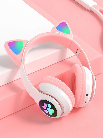 Pink headphones with cat ear design and paw print on a pink background